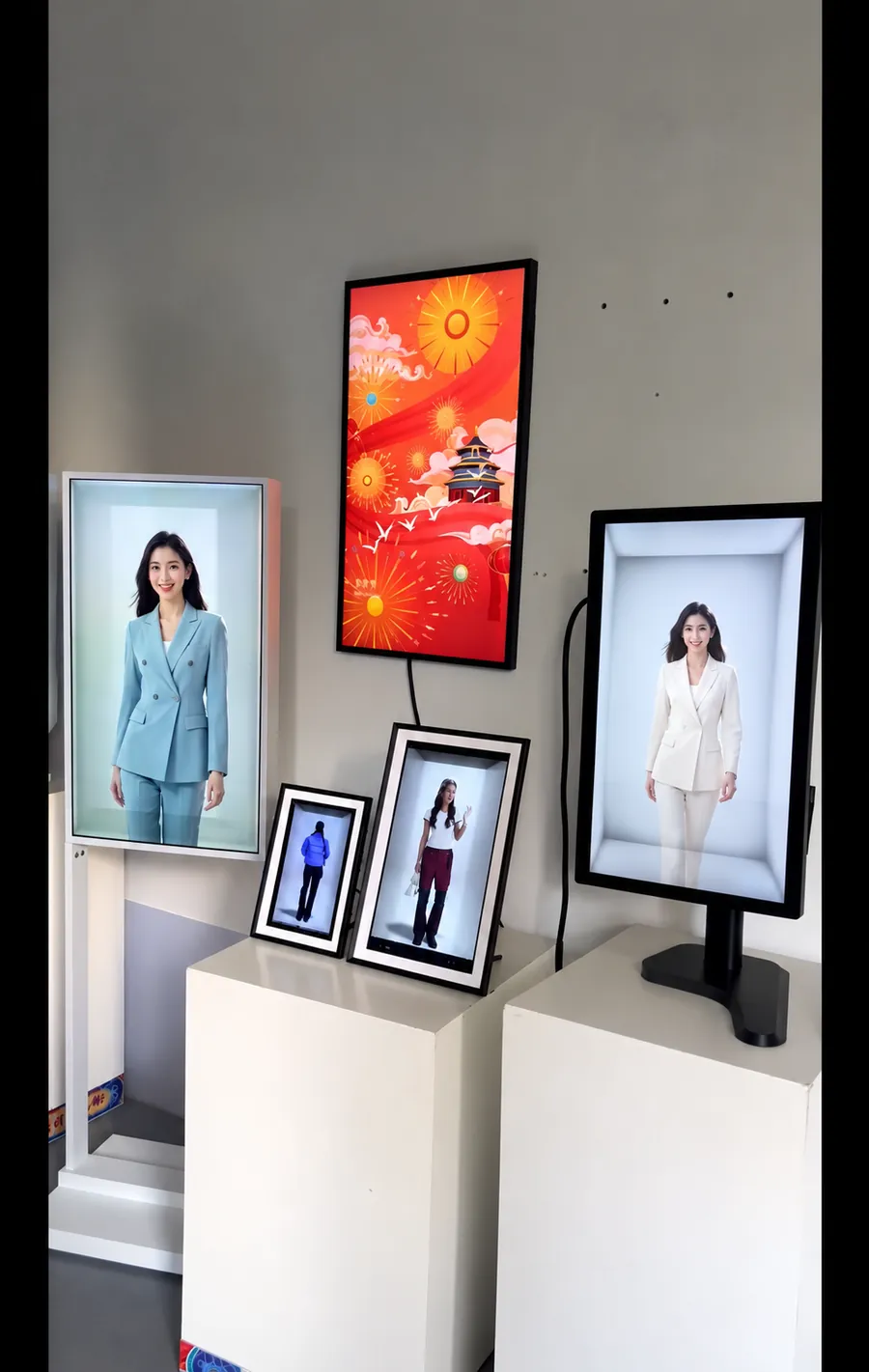 Five holographic displays of different sizes on white plinths in a showroom, each showing a life-size presenter.
